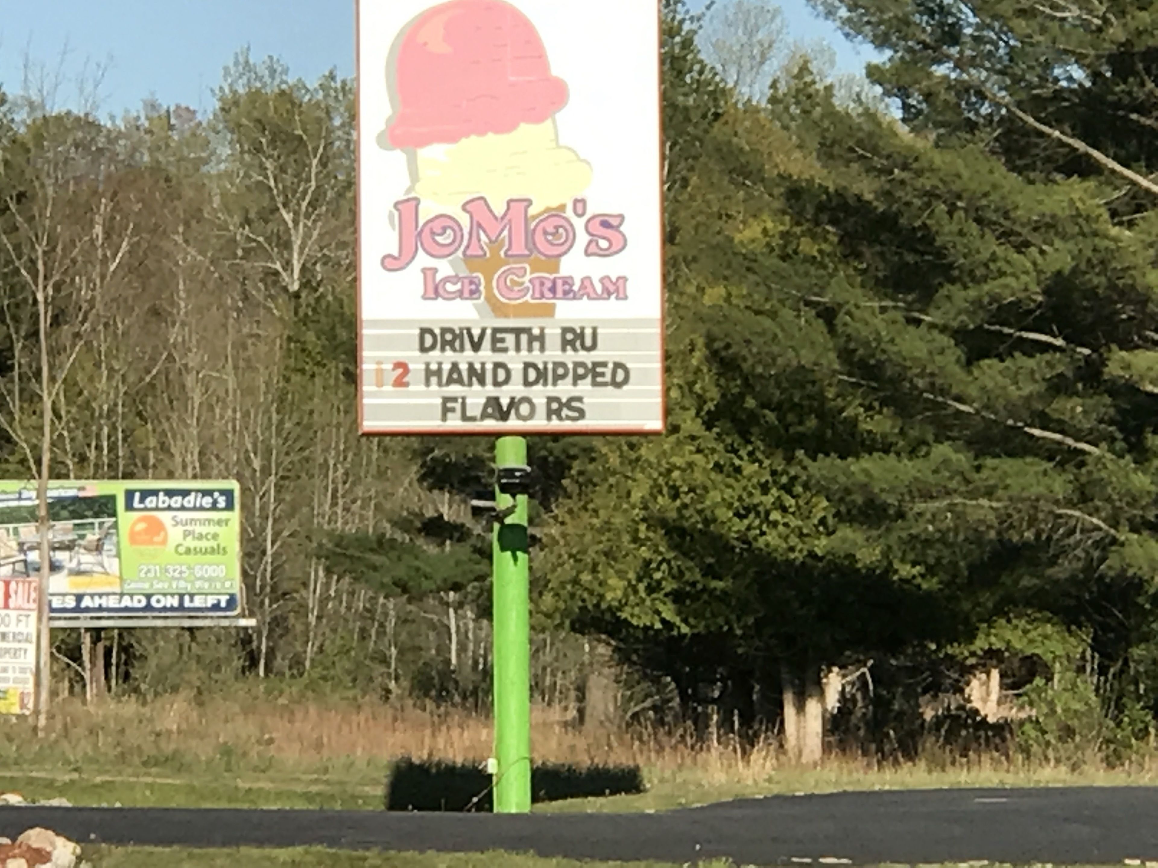 Un letrero de JoMo's Ice Cream que anuncia una opción de sabor con cobertura manual.