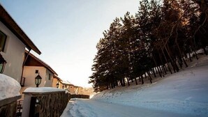 A snow-covered street with buildings and trees. - Crystal Hill Villas (Borjomi)
