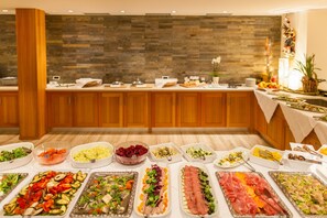 Un buffet proposant une variété de plats, avec un mur en pierre en arrière-plan.