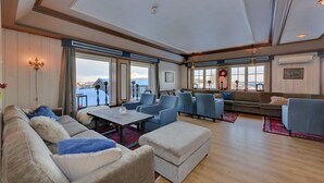 A spacious living room with a large window, a sofa set, and a coffee table. - Gomobu Fjellstue (Vestre Slidre)