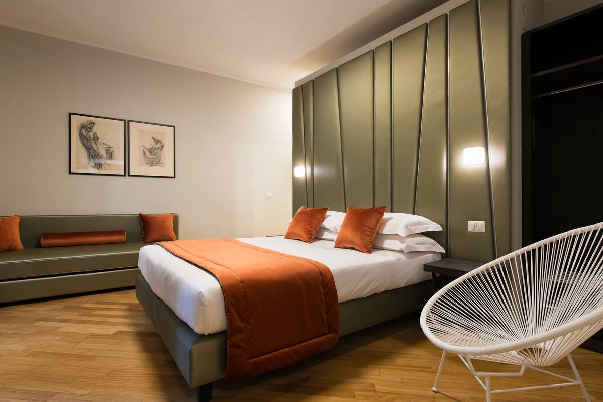 Un dormitorio moderno con cama, sofá y sillón.
