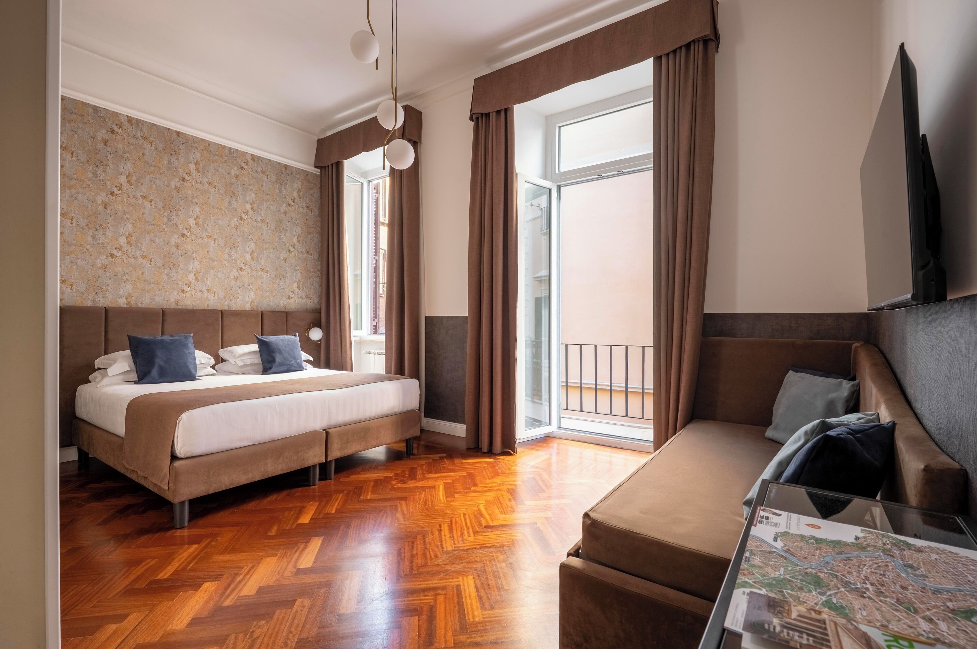 Ein Hotelzimmer mit Bett, einer Couch, einem Glastisch mit einer Karte und Blick ins Freie.