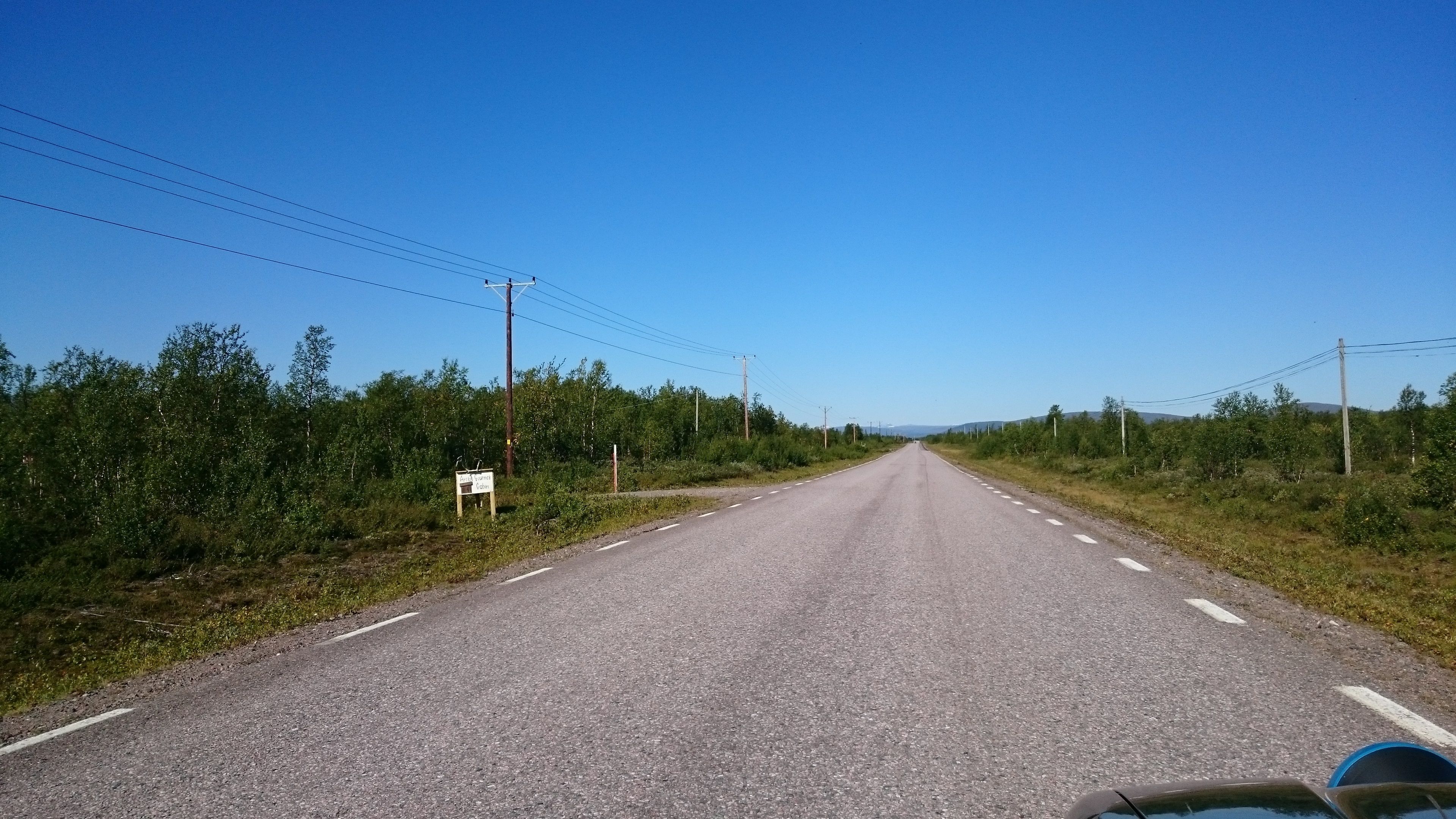 Un camino rural con un cartel a la izquierda.