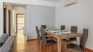 A dining area with a wooden table set for six, six black chairs, and a modern air conditioning unit on the wall. - Elvita Spata Luxurious Villa (Spata-Artemida)