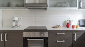 A modern kitchen with a built-in oven, a stovetop, and a coffee maker. - Elvita Spata Luxurious Villa (Spata-Artemida)