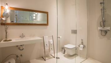 A modern bathroom with a glass-enclosed shower, a white sink, and a mirror above the vanity.