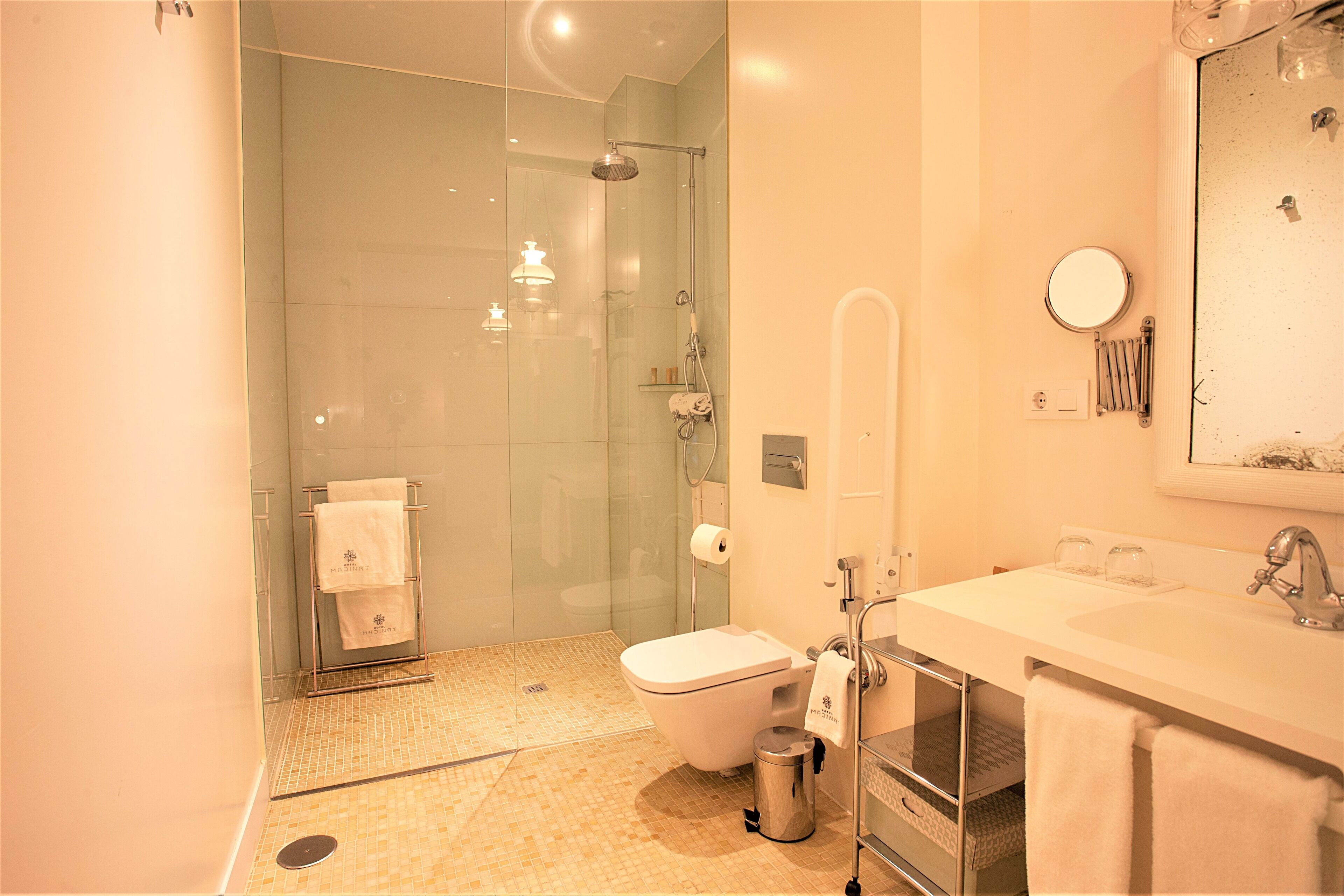 Une salle de bain moderne avec une douche à parois de verre, un lavabo blanc et un miroir.