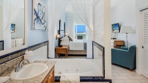 A bathroom with a sink, bathtub, and a large mirror. - The Reef Beach Resort - All Inclusive - East End, Grand Cayman (East End)