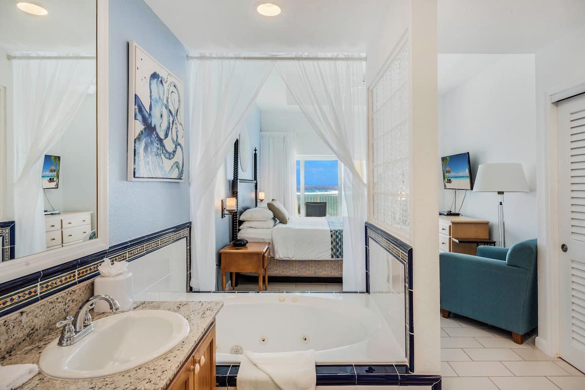 A bathroom with a sink, mirror, and bathtub.