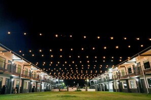 A hotel with multiple floors, outdoor lighting, and a central courtyard.