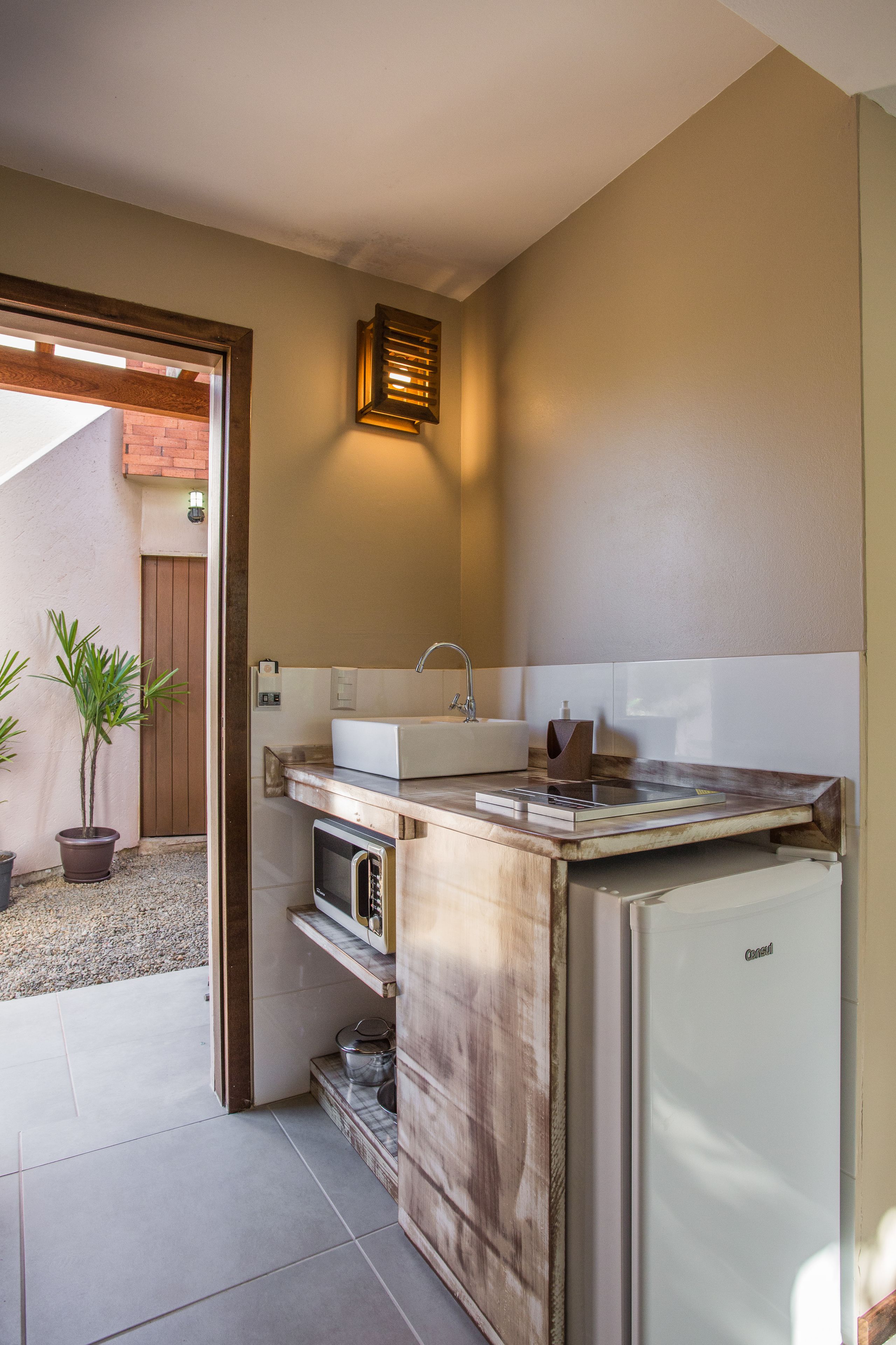 Cocina compacta con pileta integrada, microondas y refrigerador.