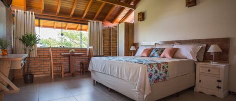 Un dormitorio con una cama grande, un escritorio y una ventana con cortinas.