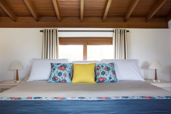 A bedroom with a bed, two nightstands, a window with curtains, and a wooden ceiling. - Pousada Areias Do Rosa (Imbituba)
