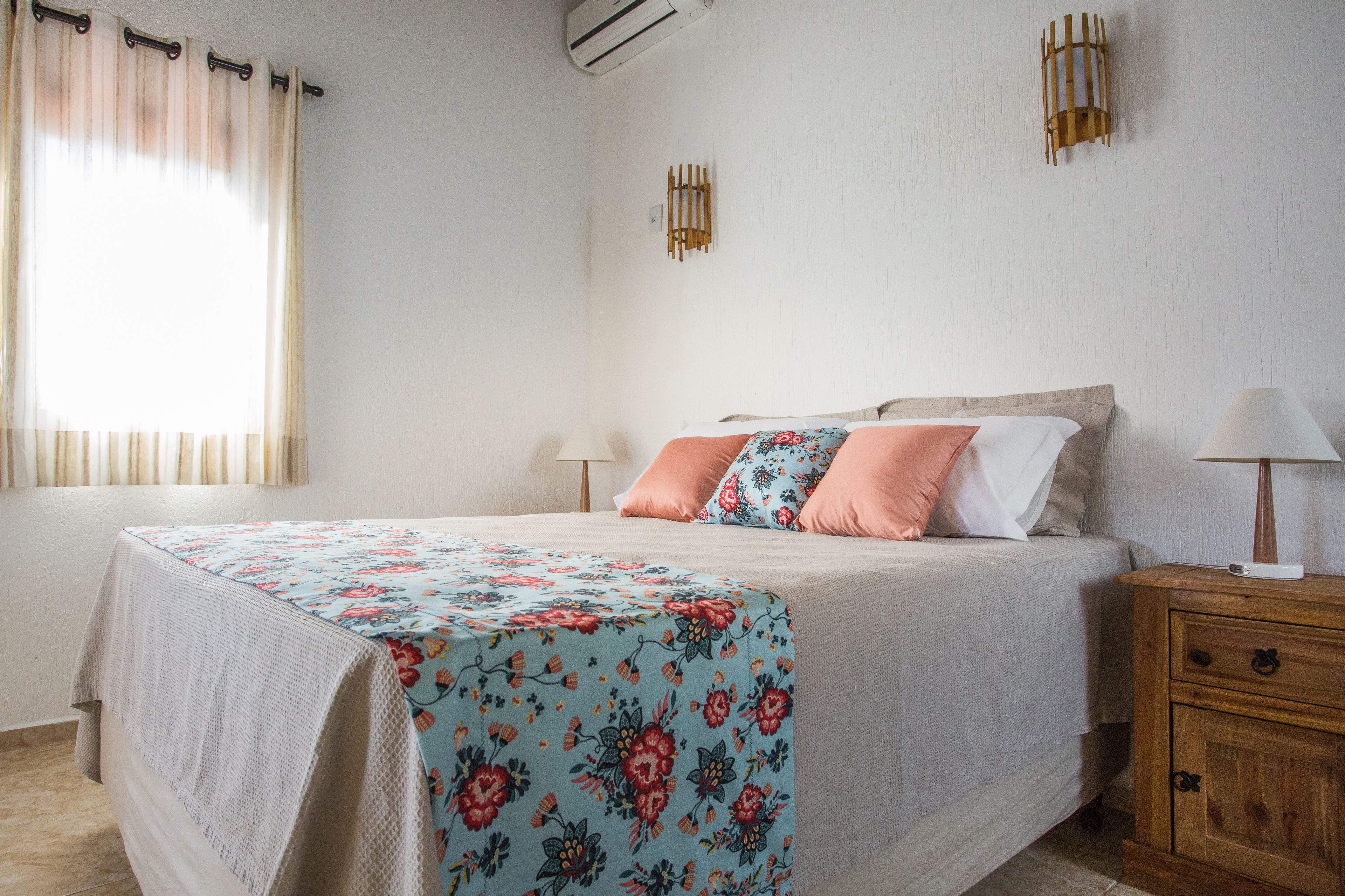 A bedroom with a bed, bedside tables, and a window with curtains.
