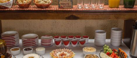 Una mesa de buffet con diversos alimentos, como pan, frutas y salsas.