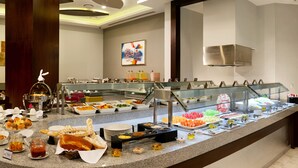 A buffet area with various food items and a seating area with chairs and tables. - HS HOTSSON Hotel Irapuato (Irapuato)