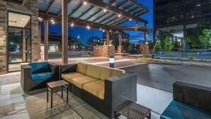 An outdoor seating area with wicker furniture and a glass canopy. - Hyatt Place Boise/Downtown (Boise)