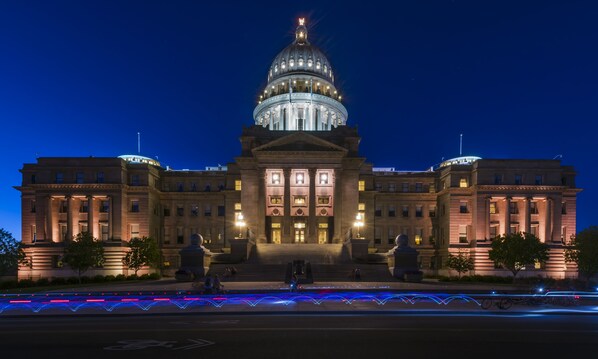 A large, historic building with a prominent dome and symmetrical facade, featuring classical columns and a central entrance.