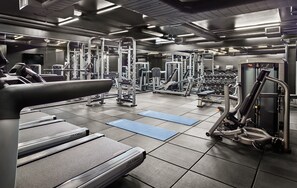 A gym with treadmills, weight machines, and free weights.