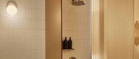 A modern bathroom with a glass shower enclosure, a toilet, and a sink.