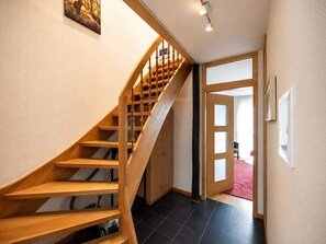 A wooden staircase leading to a room with a door and a window.