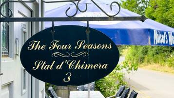 Naamplaatje voor 'The Four Seasons P'tal d'Chimera 3' met terras en een blauwe parasol.