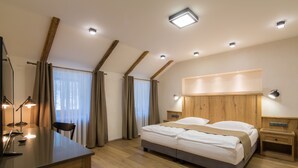 Een moderne slaapkamer met een groot bed, nachtkastjes, een bureau en een stoel.