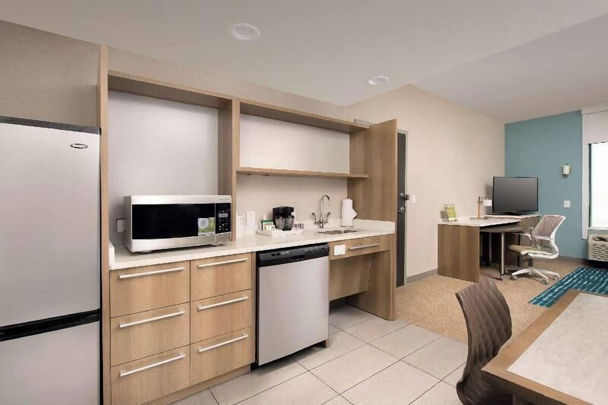 A compact kitchen with a microwave, dishwasher, and a small sink.