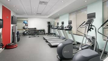 A gym with treadmills, elliptical machines, and weightlifting equipment.