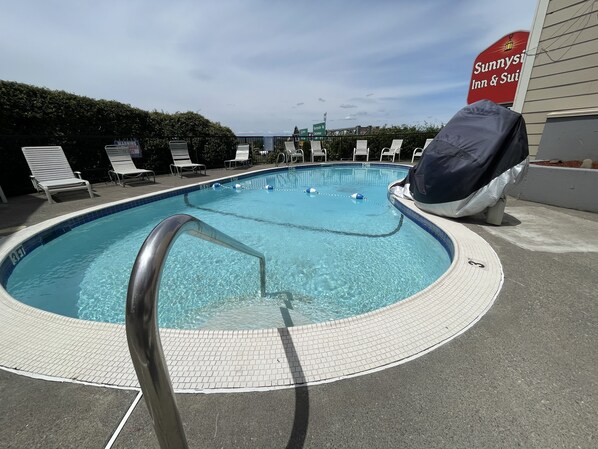 Piscine extérieure en saison, parasols, chaises longues