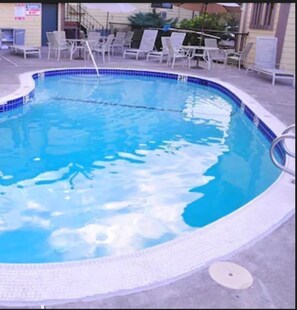 Piscina a l'aire lliure de temporada, para-sols i gandules 