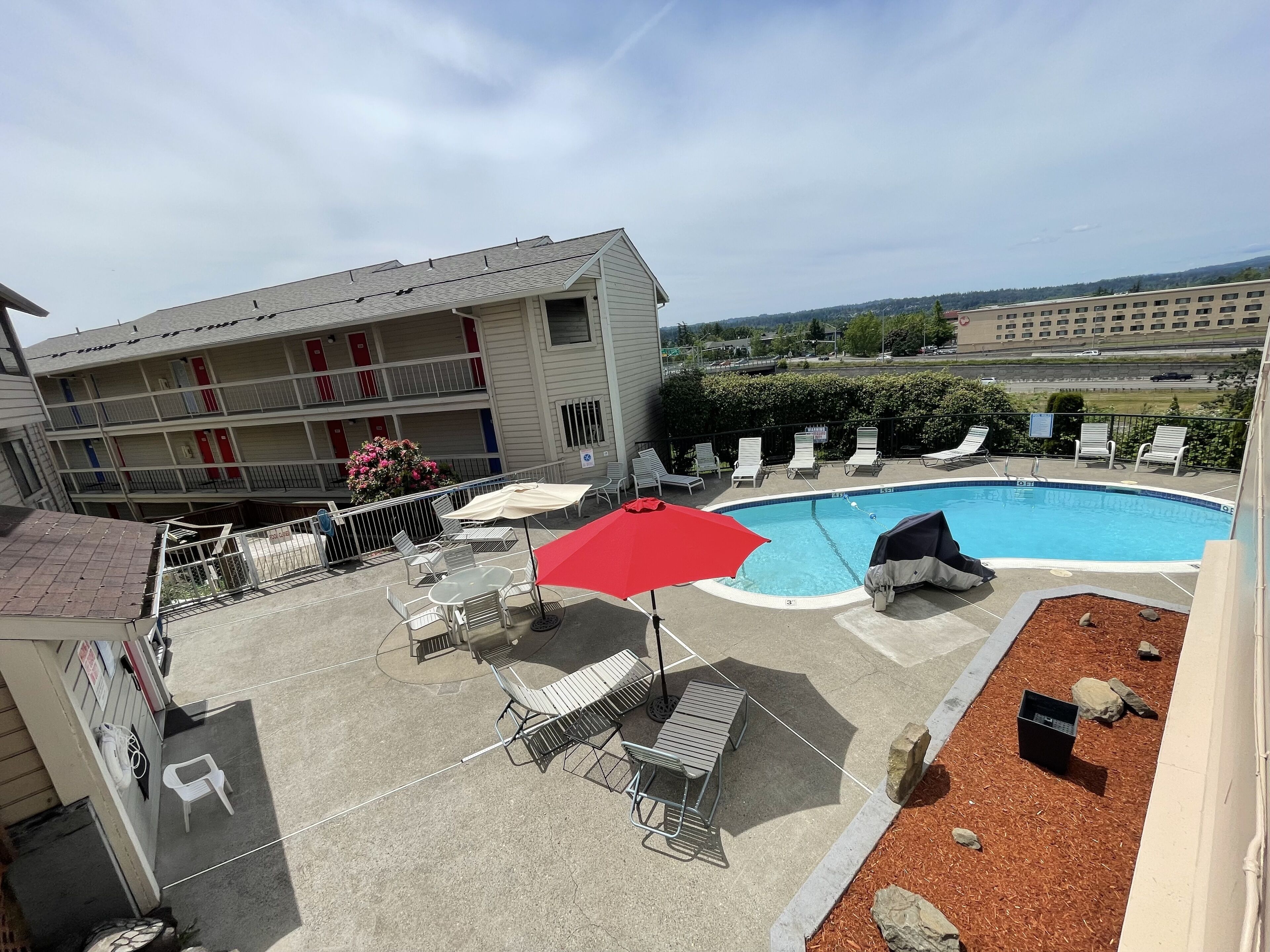 Una piscina al aire libre de temporada, sombrillas, tumbonas