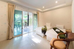 Habitación de hotel con una cama, una silla y vistas al exterior a través de un ventanal corredizo.