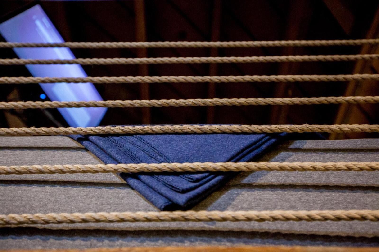 A boxing ring with ropes and a folded piece of clothing in the center.