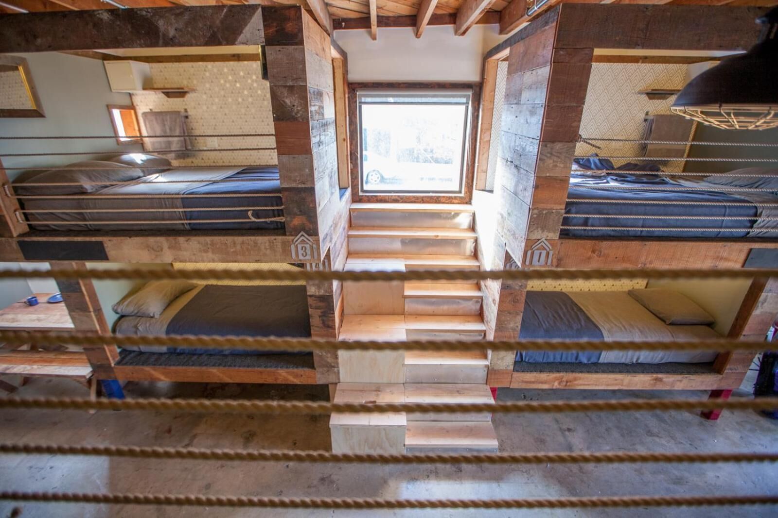 A multi-level bunk bed room with a central staircase.