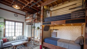 Ett rum i loftstil med en våningssäng, en soffa och ett litet bord.