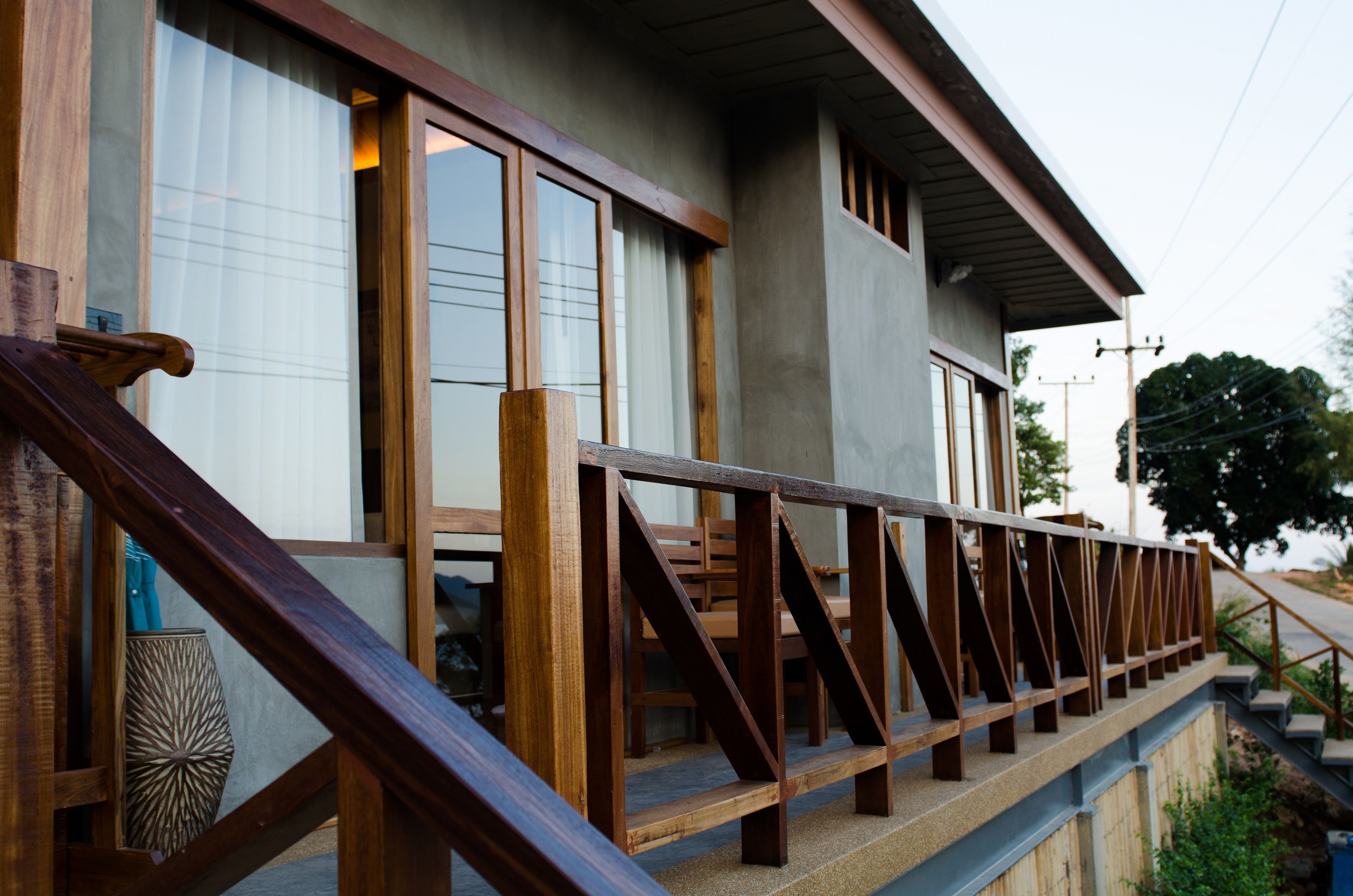 A wooden staircase leading to a balcony with a railing.