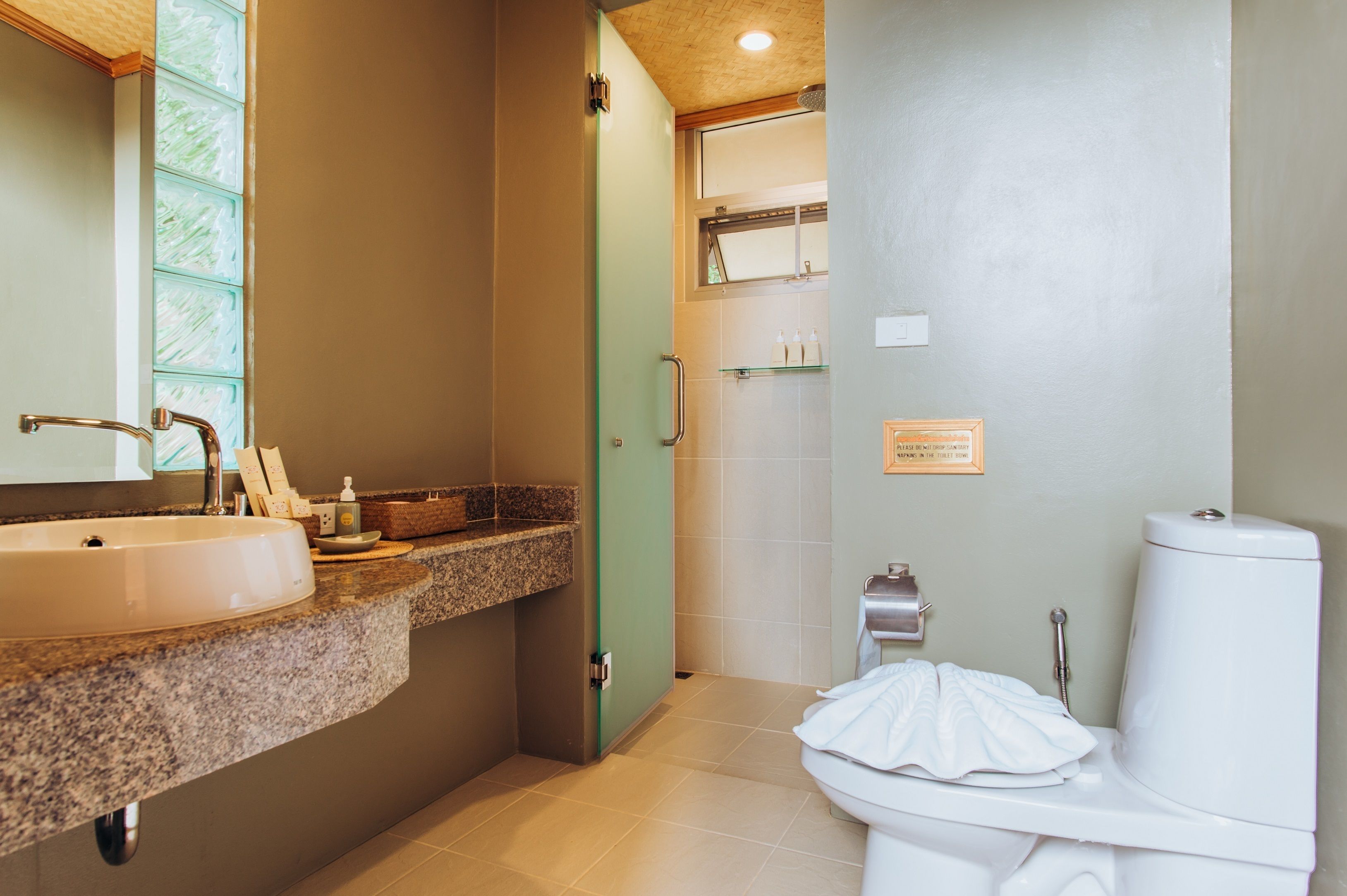 Une salle de bain avec un lavabo, des toilettes et une douche.