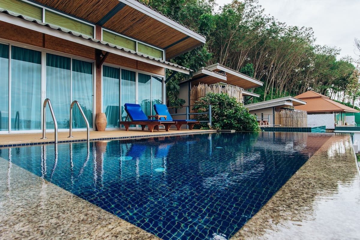Une piscine avec des chaises longues et une terrasse en bois.