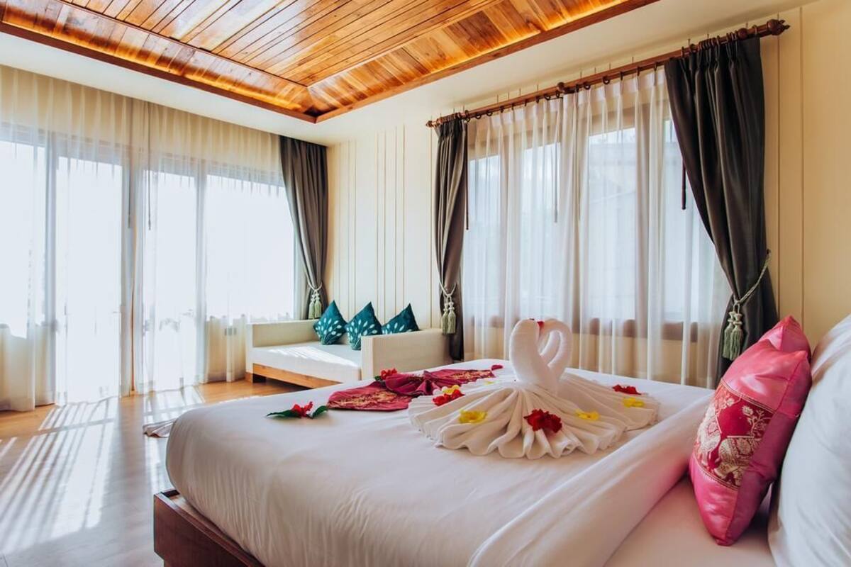 Une chambre d’hôtel avec un grand lit, un plafond en bois et une vue sur la ville.