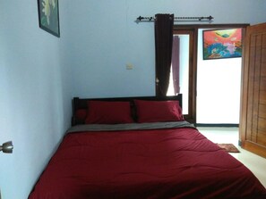 A bedroom with a bed, a door, and a window. - Jazzi Homestay (Wonokitri)