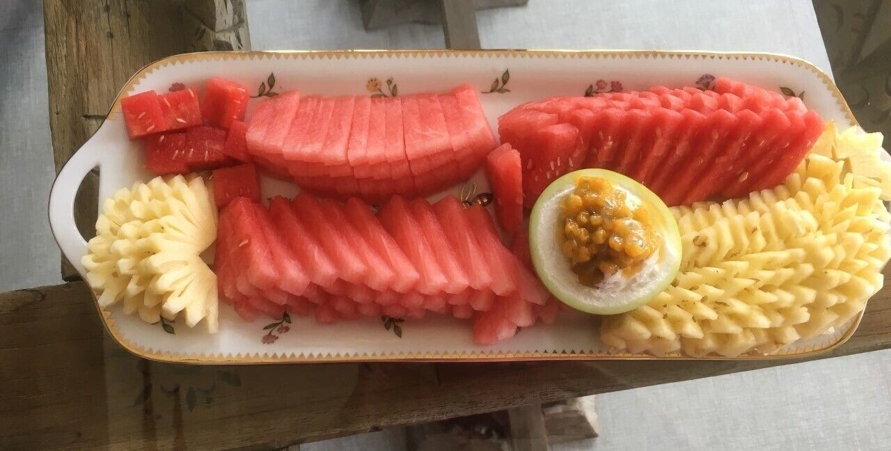 Ein Tablett mit Obst verschiedener Art und einer halbierten Melone.