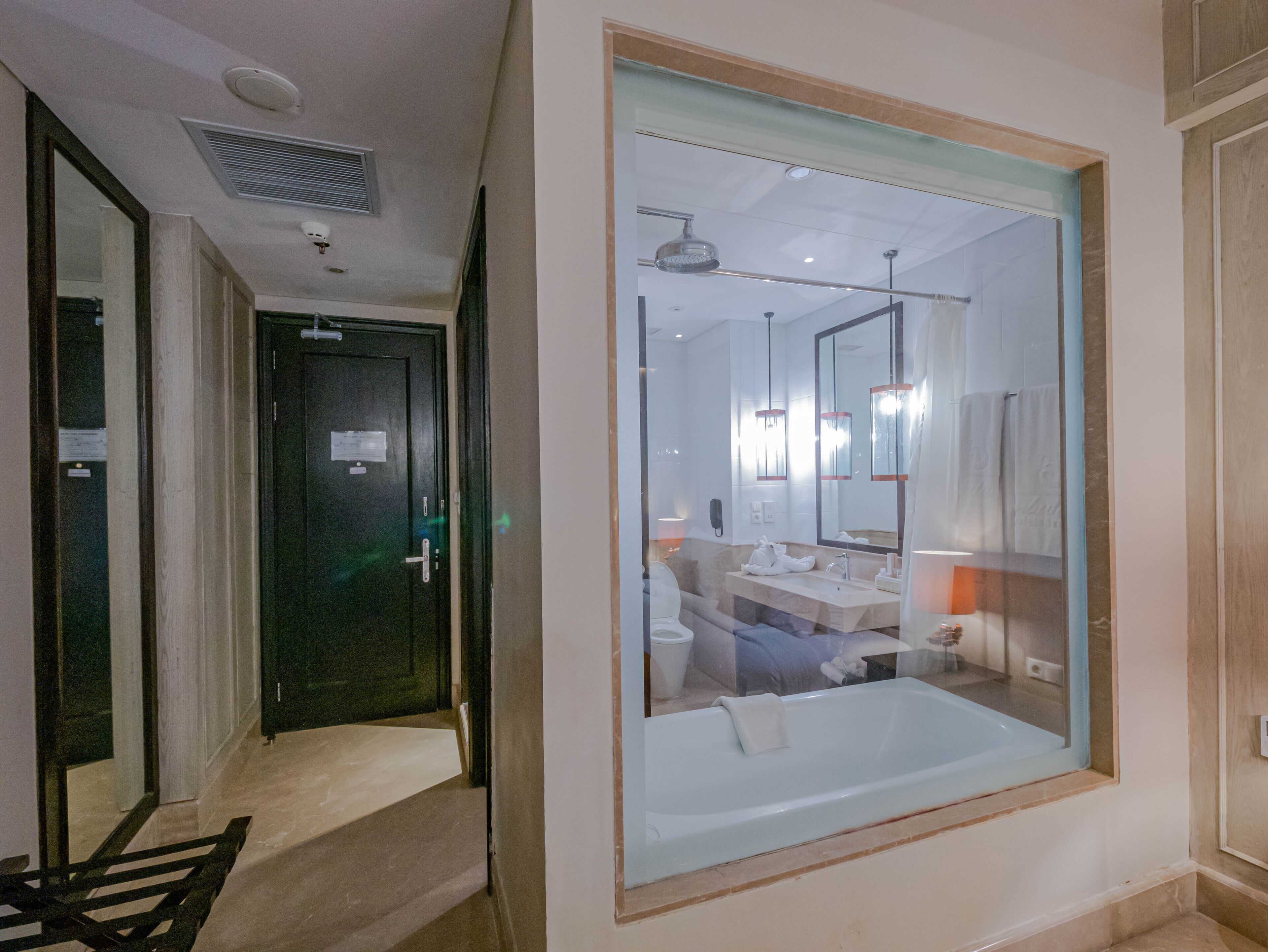 Un baño moderno con un espejo grande, una bañera y un tocador.