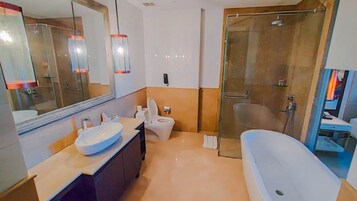 Un baño moderno con un espejo grande, un lavabo, un inodoro y una zona de ducha.