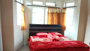 A bedroom with a bed, curtains, and a window. - Villa Tamie Bumi Ciherang (Cipanas)