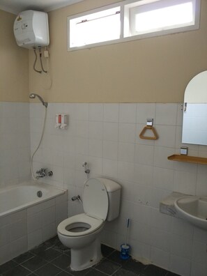A bathroom with a bathtub, toilet, and sink. - Villa Tamie Bumi Ciherang (Cipanas)