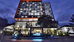 A modern hotel with a prominent 'THE101' sign, multiple floors, and a well-lit entrance.