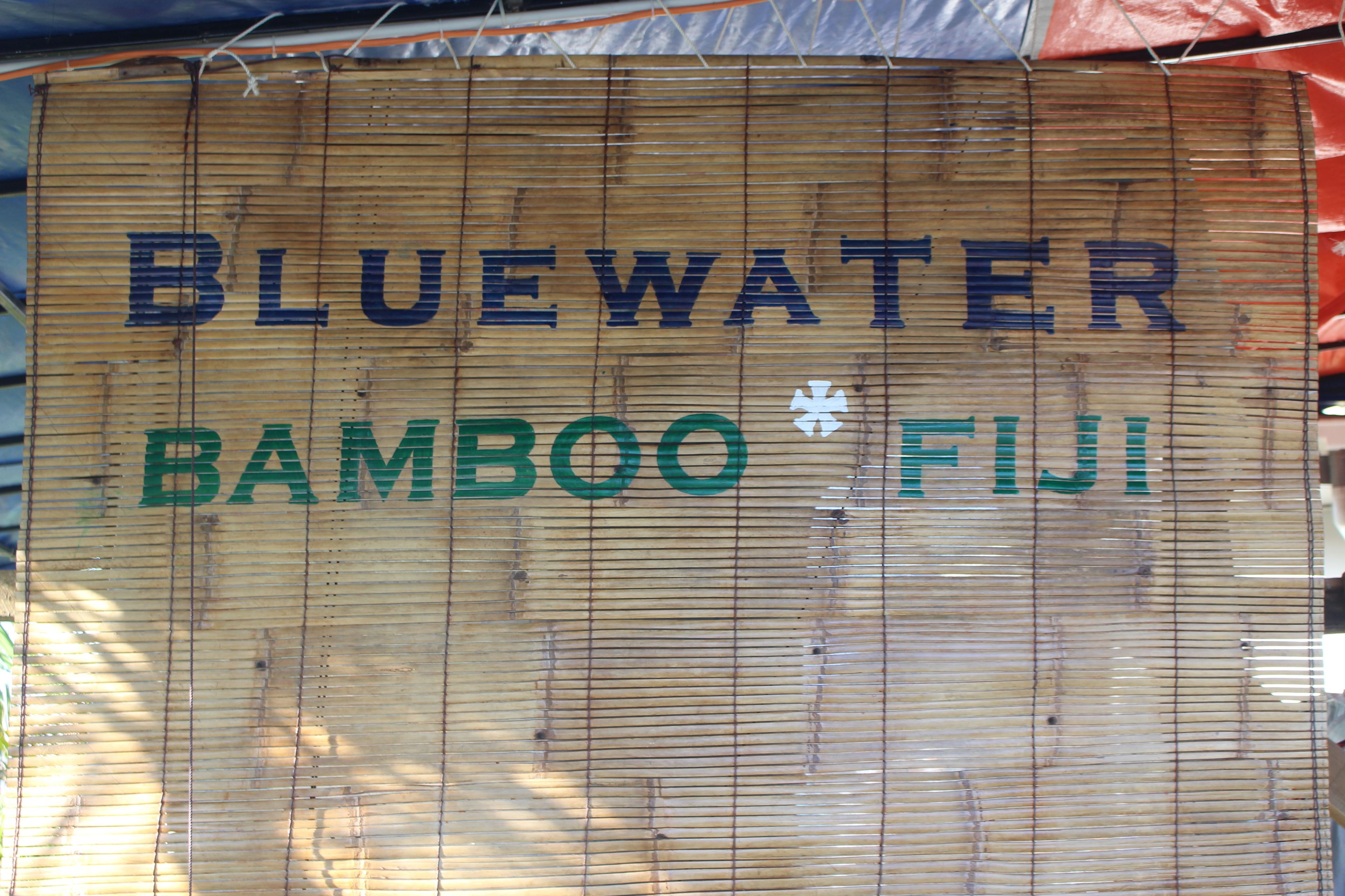 A bamboo screen with the text "BLUEWATER BAMBOO FIJI" written on it.