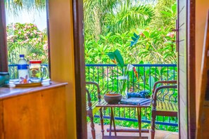 A view from a balcony with a table, chairs, and a railing. - Griya Sriwedari (Ubud)