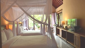A bedroom with two beds, a TV, and a cabinet. - Griya Sriwedari (Ubud)
